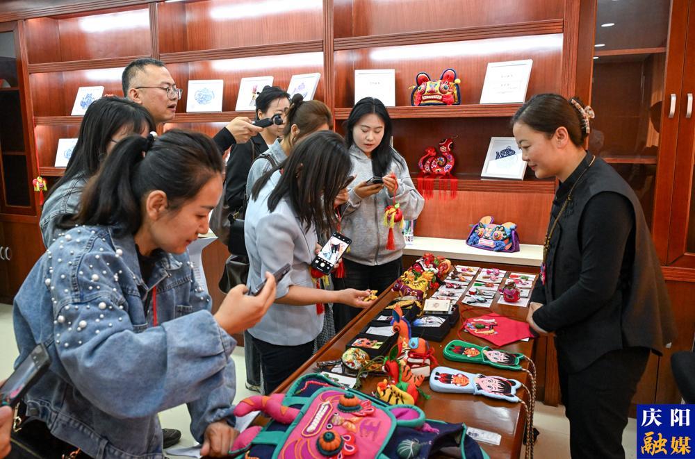 第二十屆慶陽香包民俗文化節新聞發布會現場,參會記者拍攝慶陽香包。